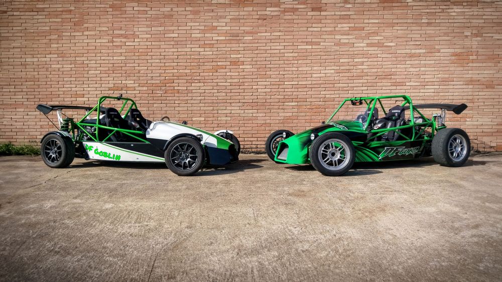 Early DF Goblin V1 prototypes, green and black, side by side against a brick wall