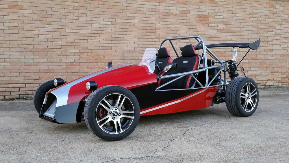 Finished DF Goblin V1 with red and silver body panels parked by a brick wall