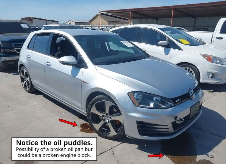 Silver Mk7 Golf GTI at a salvage lot with visible oil puddles beneath the car, indicating a potential oil pan or engine block issue.