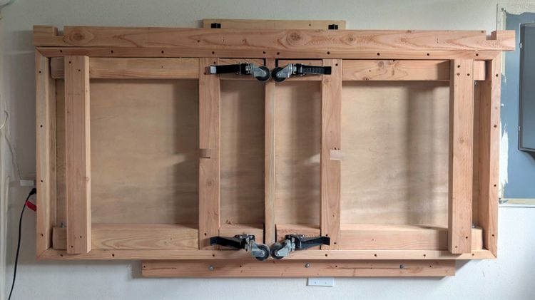 A DIY wall-mounted folding workbench, in the folded-up position.
