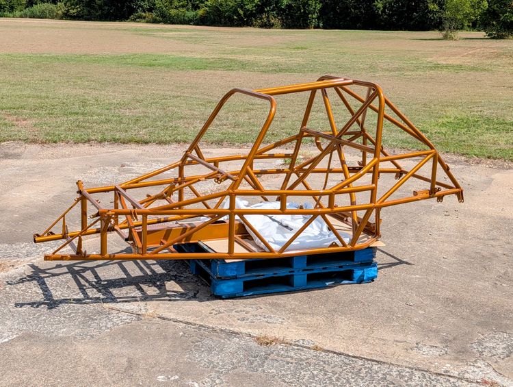 Goblin V2-008 chassis powder coated in Illusion Spanish Fly gold, sitting on a pallet outdoors, showing the T-Top hoop, rear cage X brace, and standard door bars