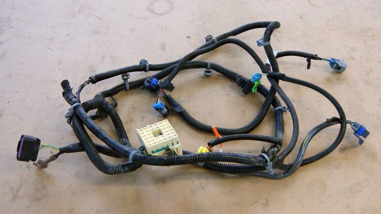 Headlight wiring harness from a Cobalt donor vehicle, arranged on a work surface showing headlight plug connectors.