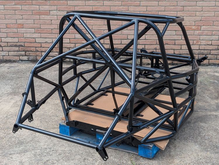 Close-up view of the rear of Goblin V2-002 showing the main hoop X-brace behind the occupant area and the rear cage X-brace above the engine bay, both finished in gloss black.