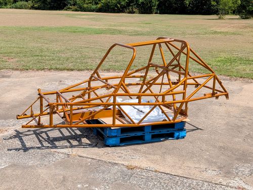 Goblin V2-008 chassis powder coated in Illusion Spanish Fly gold, sitting on a pallet outdoors, showing the T-Top hoop, rear cage X brace, and standard door bars